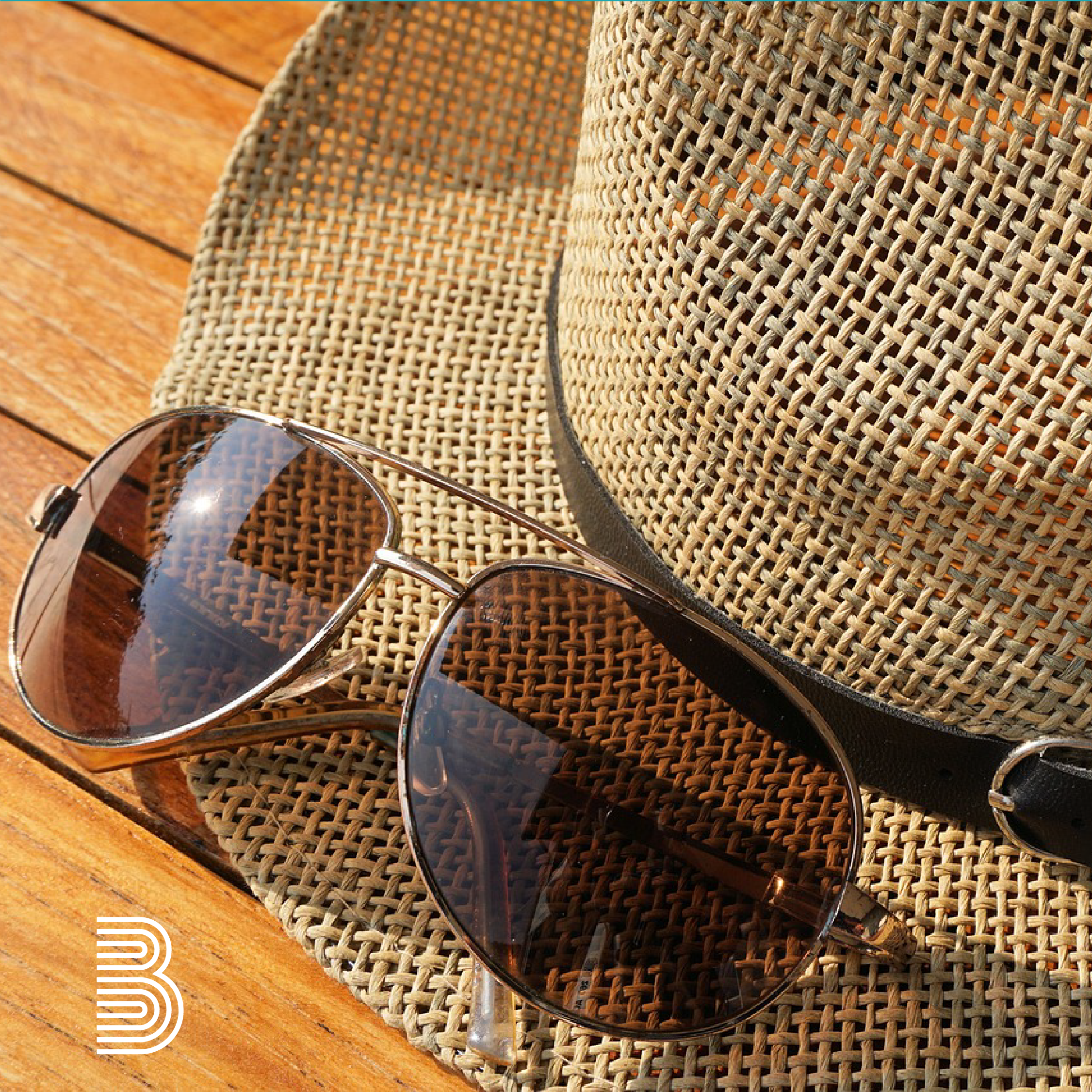 Sonnebrille liegt auf Sommerhut.