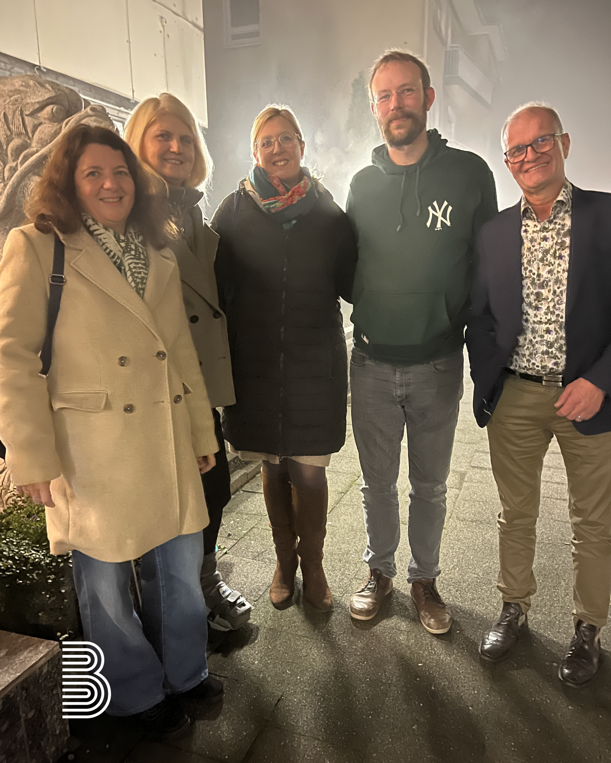 Ein Teil des Teams der Firma Berse steht nebeneinander beim Restaurantbesuch.