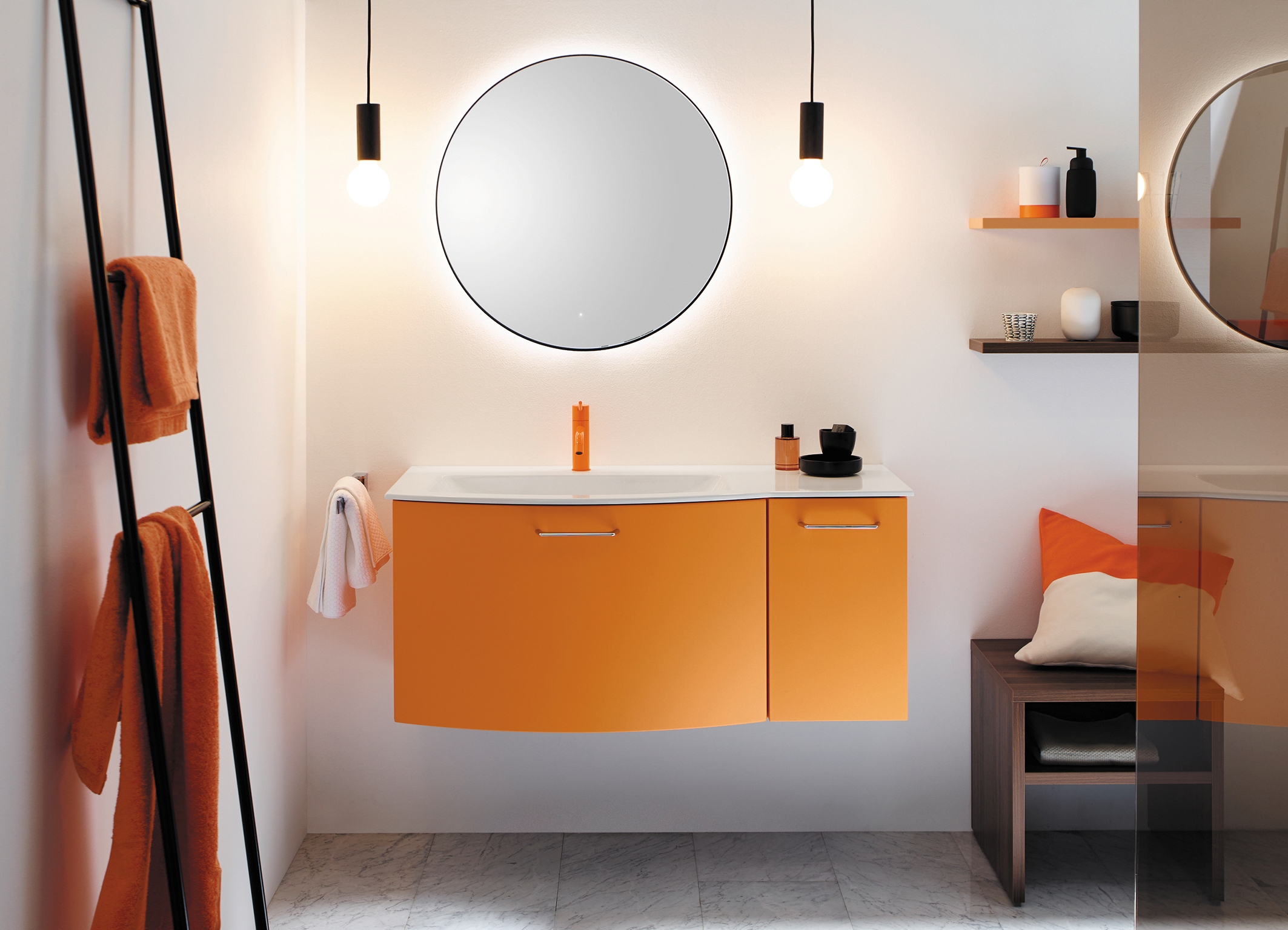 Ein orangefarbener Waschtisch mit rundem Spiegel und Badezimmereinrichtung.