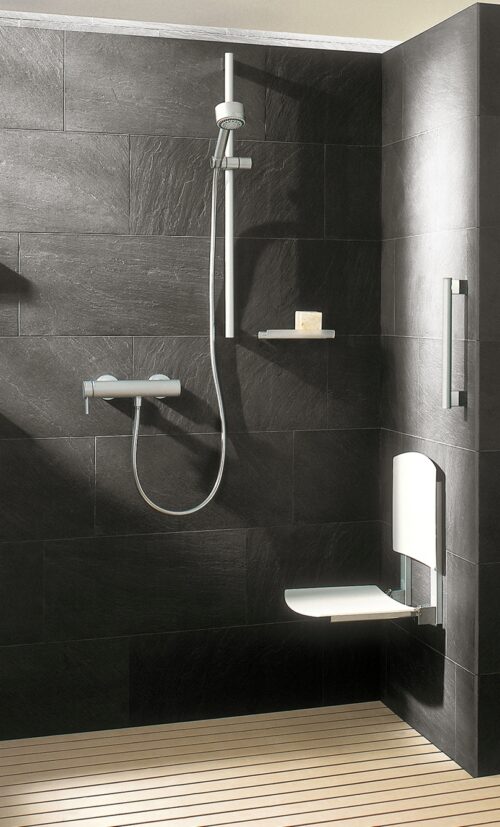 Eine Dusche mit in der Wand montiertem Duschsitz.