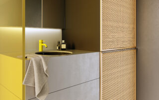 Ein Waschtisch mit gelben Farbtönen an Armatur und Seitenwand.
