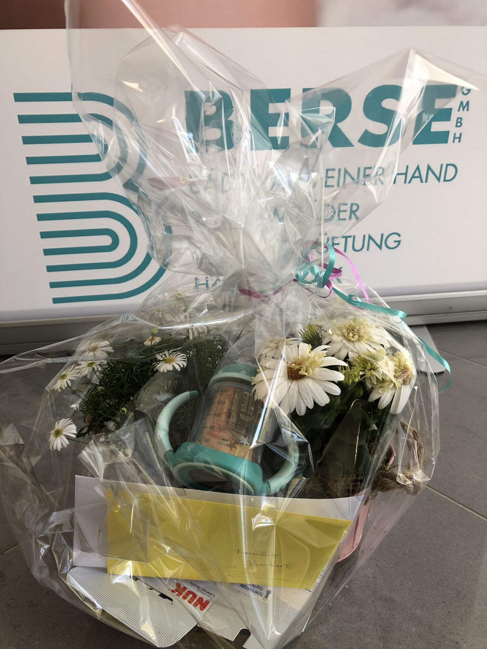 Ein hübsch verpackter Geschenkkorb mit Babysachen darin.