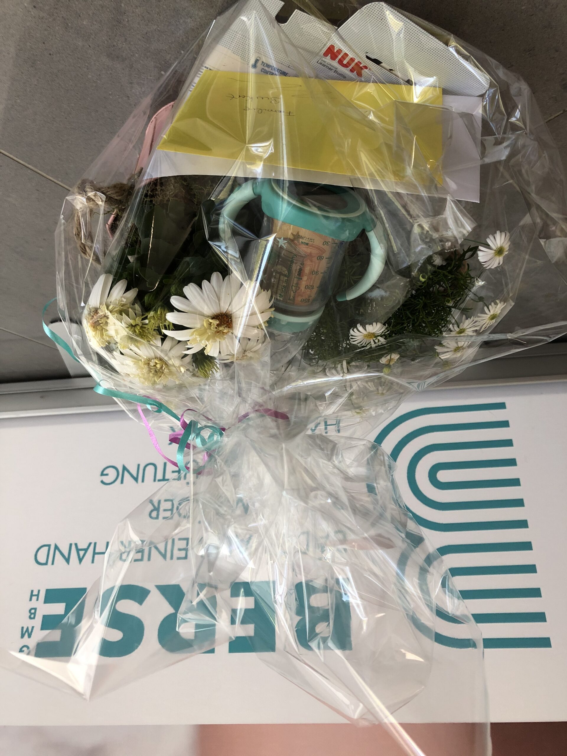 gedreht_babygeschenkkorb_img_7586 Ein hübsch verpackter Geschenkkorb mit Babysachen darin.