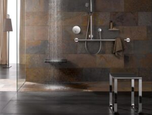 Eine Dusche, die läuft und ein Duschsitz. 
