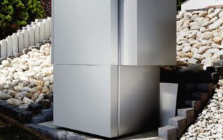 Eine Wärmepumpe steht vor einem Haus.